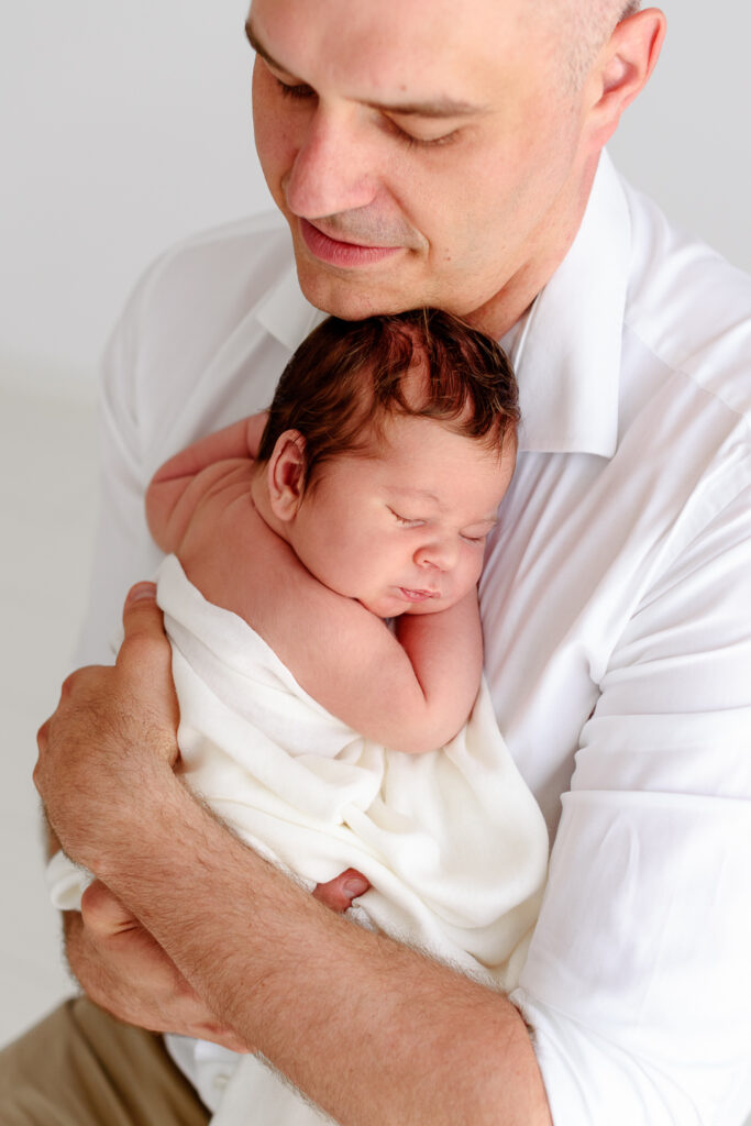 noworodek w ramionach taty